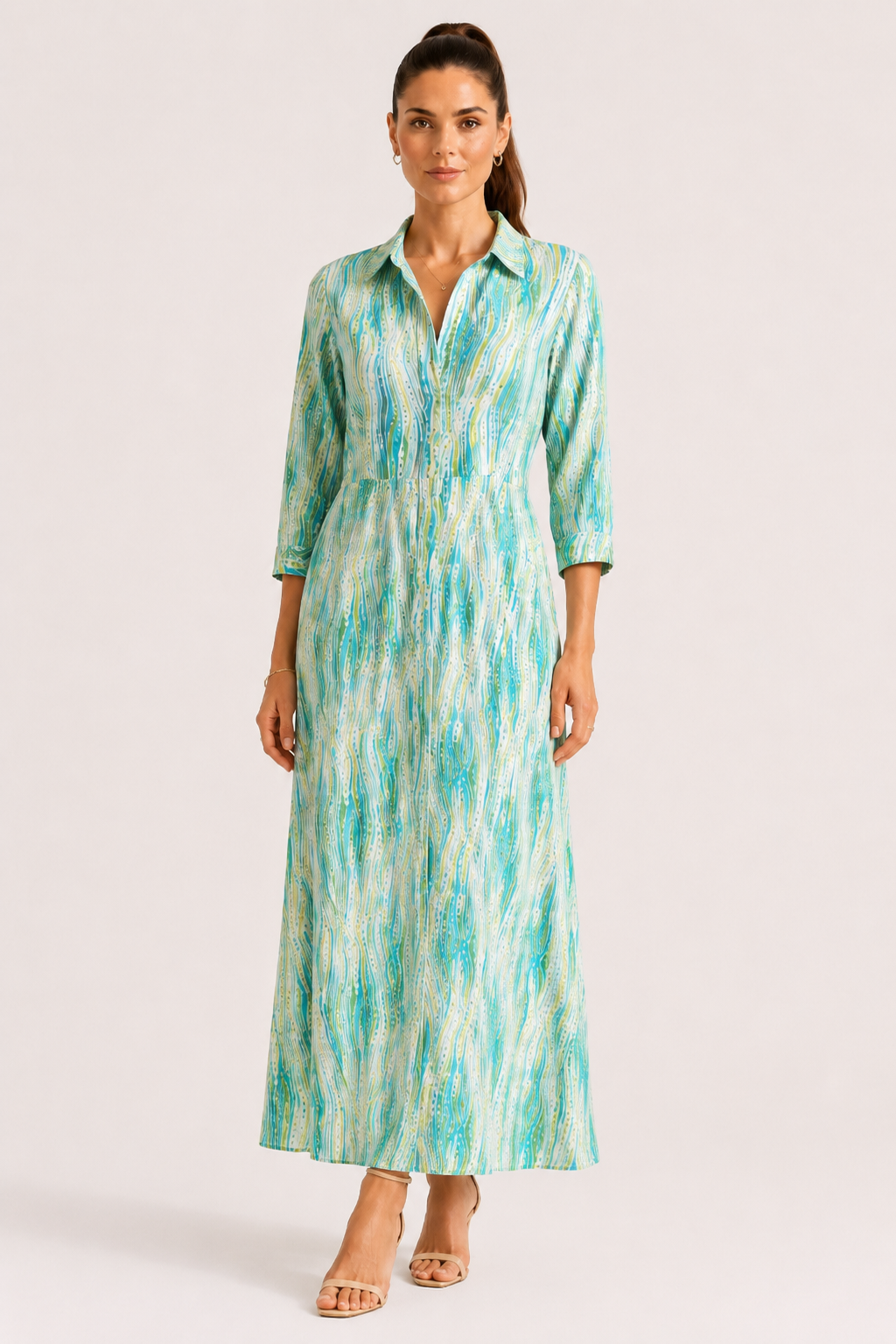 Woman wearing a green and blue patterned dress on a white background