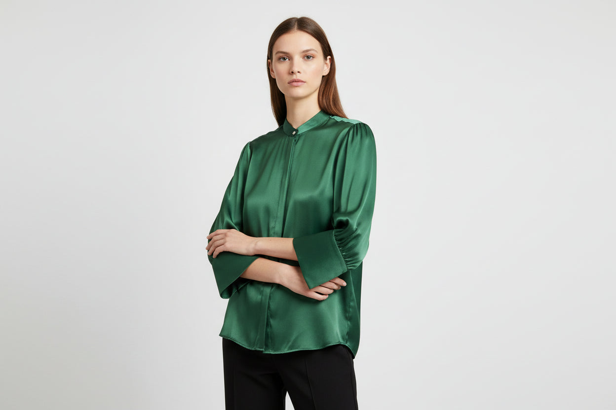 Green satin blouse with long sleeves on a white background